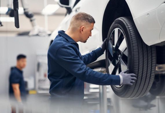 Technik zkoumá pneumatiky vozu Volvo